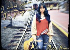 holding guitar by railroad tracks